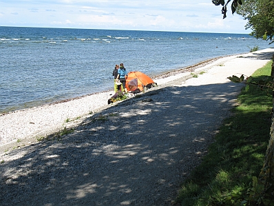 bild - två tjejer och ett tält på stenig strand vid strandpromenaden i visby